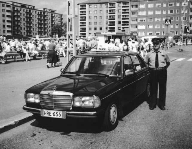 Kuvassa taksiauto ja mies. Kuva on vuodelta 1984 ja kuvan mies on Veikko Salo ja auto MB 240.